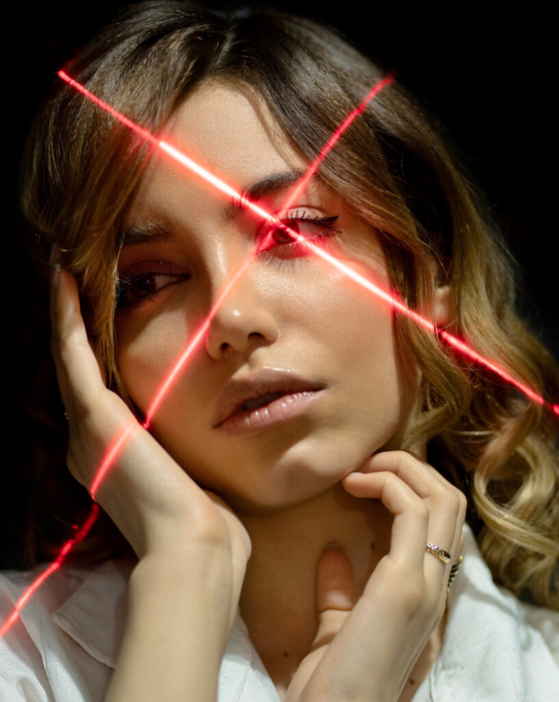 Depilación Láser:<br>El Complemento Perfecto Antes de Tatuarte 3 canva gentle ethnic model touching face in laser rays MAEffV85GyA